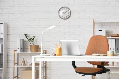 Ofiste dizüstü bilgisayarı, kum saati ve fincanı olan işyeri