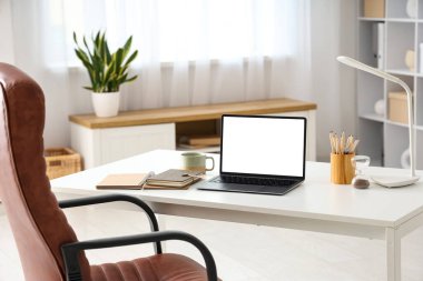 Boş dizüstü bilgisayarı ve ofisinde fincanı olan işyeri