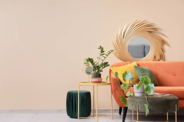 Rahat kahverengi kanepe, ev bitkileri ve püf noktaları oturma odasının içinde.