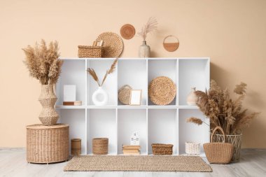 İçinde raf ünitesi ve vazolarda otlar olan bir oda.