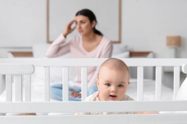 Beşikteki küçük bebek, doğum sonrası depresyon geçiren anneye karşı, yakın plan.