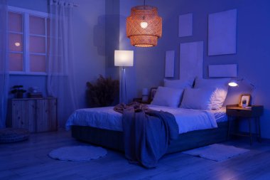 Karanlık yatak odasının içinde resimler ve parlayan lambalar var.