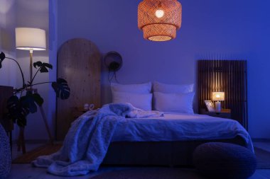 Geceleri karanlık odanın içinde yataklar, masalar ve parlayan lambalar.