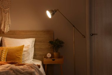 Masası ve parlayan lambası olan karanlık yatak odasının içi.