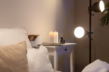 Mumları şarjörle yakmak ve yatak odasındaki masada sazlık ayırıcı.