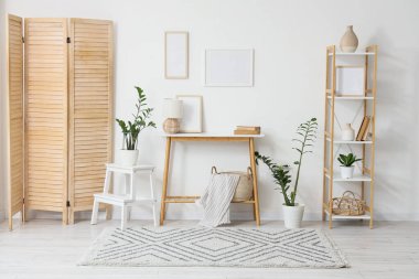 Boş çerçeveli, tablo ve katlanan ekranlı ışık odasının içi