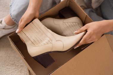 Evdeki karton kutuda çizme saklayan kadın, yakın plan.