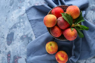 Mavi arka planda bir kase taze şeftali.