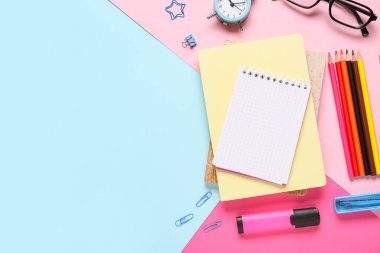 Çalar saat, not defterleri ve okul gereçleri içeren renk arkaplanı bileşimi, yakın plan