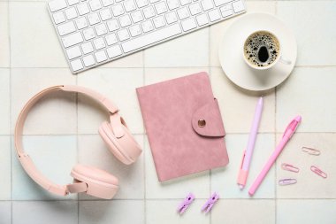 Klavyeli kompozisyon, bir fincan kahve, kulaklık, not defteri ve beyaz fayanslı okul malzemeleri, yakın plan