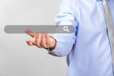 Bir şey gri arka plan üzerinde tutan genç işadamı