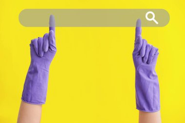 Sarı arka planda web arama motoru kullanan lastik eldivenli eller