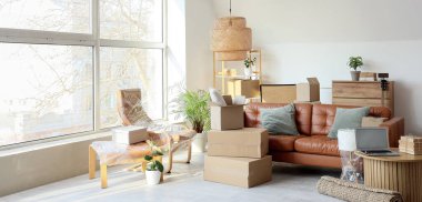 Taşındığı gün oturma odasında streç film, kanepe ve karton kutularla sarılı bir koltuk.