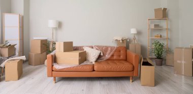 Taşındığı gün içinde film ve karton kutular olan kahverengi kanepe