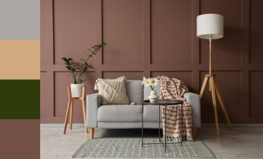 Gri kanepe, yer lambası ve vazoda papatya çiçeğiyle oturma odasının içinde. Farklı renk desenleri