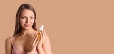 Bej arka planda kozmetik ürünleri olan güzel genç bir kadın ve metin için yeri var.