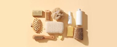 Banyo süngerleri, masaj fırçaları ve bej arka planda kozmetik ürünleri olan kompozisyon