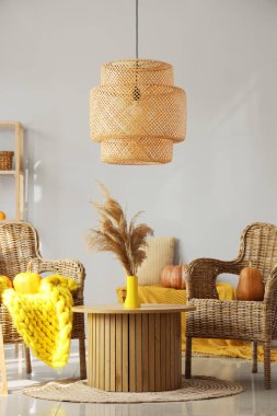 Sehpanın üzerinde hasır koltuklar, balkabakları ve pampalar olan sonbahar içleri.