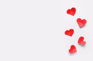 Işık arkaplanda kırmızı kağıt kalplerle kompozisyon. Sevgililer Günü kutlaması