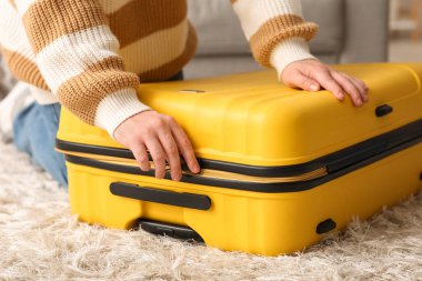 Evdeki bavulu kapatan adam, yakın plan.