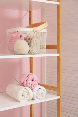 Havluların olduğu raflar şık bir banyonun içinde, yakın plan.