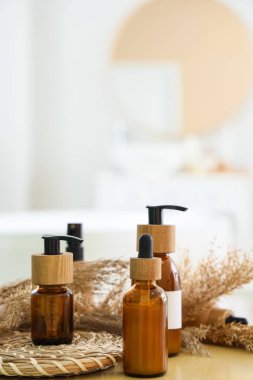 Banyodaki masada otla kaplı kozmetik şişeleri, yakın plan.