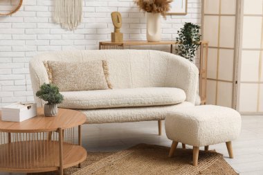 İçinde kanepe, masa, puf ve katlanan ekran olan modern ışık oturma odası.