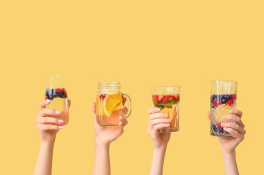 Sarı zemin üzerinde aşılanmış su olan birçok el