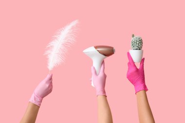 Fotokopi makinesi, tüy çubuğu ve pembe arka planda kaktüs olan kadın elleri. Yasaklama kavramı