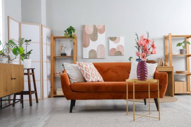 Oturma odasının içinde, sehpadaki vazoda manolya çiçekleri var.