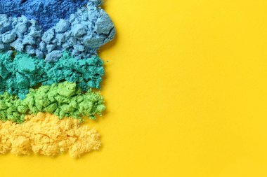 Sarı arkaplanda farklı renk toz pigmentleri kümesi