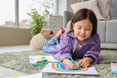 Evdeki halıya resim çizen tatlı Asyalı kız.