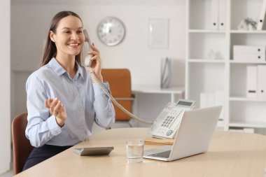 Ofiste telefonla konuşan güzel bir sekreter.