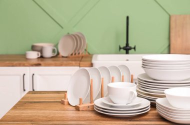 Mutfaktaki ahşap masada temiz beyaz tabaklar.