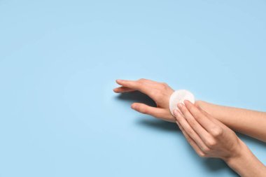 Mavi arka planda pamuk yastıklı kadın elleri