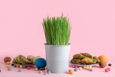Geleneksel şekerli yeşil buğday çimi ve pembe arka planda yumurtalar. Nowruz Bayram kutlaması