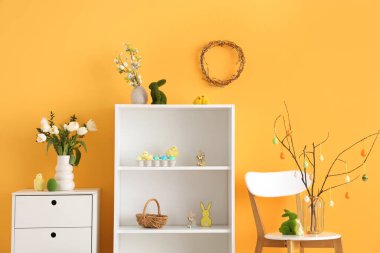 Rafların, sandalyenin ve Paskalya süslemelerinin olduğu festival salonu.