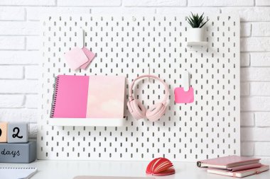 Ofisteki masasında kırtasiye ve kulaklık bulunan tahta.