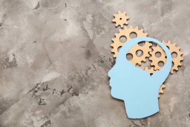 Gri arka planda ahşap dişliler olan kağıt insan kafası. Mantık kavramı
