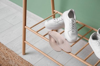 Koridorda duran ortopedik tabanlı spor ayakkabılar.