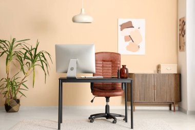 Çalışma alanı, palmiye ağacı ve tabloları olan modern ofis.