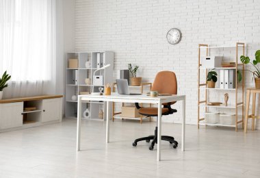 Çalışma yeri ve raf üniteleri olan modern ofisin içi