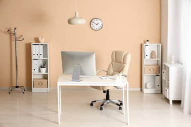 Çalışma yeri ve raf üniteleri olan modern ofisin içi