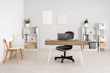 Çalışma yeri ve raf üniteleri olan hafif ofisin içi