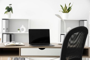 Boş dizüstü bilgisayarı ve lambası olan işyeri