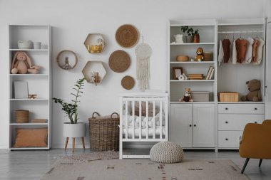 Bebek beşiği, dolap ve rafları olan bir kreş.