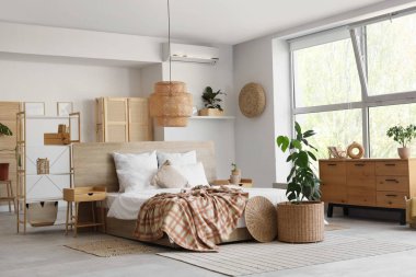 Rahat yatağı, ahşap mobilyaları ve çiçekleri olan şık bir yatak odası.