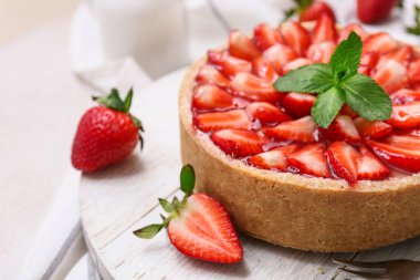 Beyaz arka planda nane şekerli ahşap çilekli tart tahtası, yakın plan.