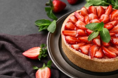 Siyah arka planda naneli tatlı çilekli tart, yakın plan.