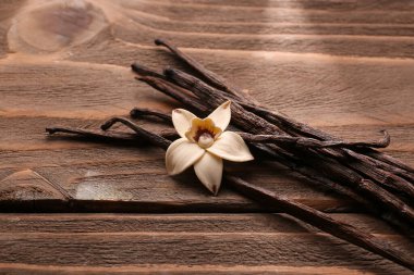 Vanilya çubukları ve ahşap zemin üzerine çiçek
